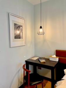 a room with a desk with a chair and a lamp at C U Inn Bangkok in Bangkok