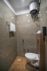 a bathroom with a toilet and a shower at Hotel Clover Inn by Onyx Group in Indore