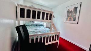 a bedroom with a bunk bed and a chair at Ground Floor Beach Front Apartment in Swansea