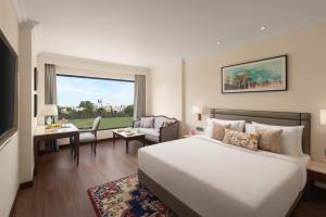 a hotel room with a bed and a living room at Sarovar Portico Hanumangarh in Hanumāngarh