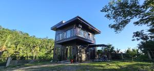 a small house in the middle of a field at Island Nest in Virac
