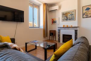 un soggiorno con divano e camino di TIKAZ Béziers - Appartement - 2 Chambres Hyper Centre a Béziers