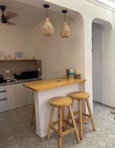a kitchen with a counter and two stools at Azure Luxury 2Bhk in Candolim