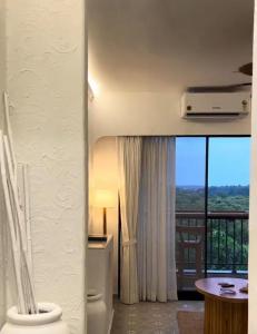a bathroom with a toilet and a window with a view at Azure Luxury 2Bhk in Candolim
