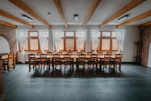 a room with a table and chairs and windows at PENZIÓN V STAROM MLYNE in Belá