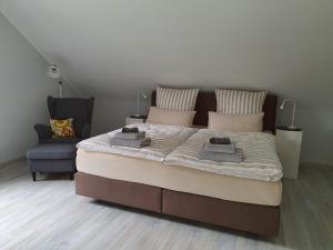 a bedroom with a large bed and a chair at Ferienwohnung Kirschenknupp in Hellendorf