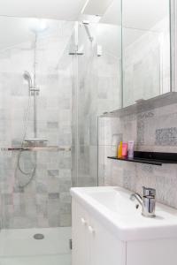 un bagno bianco con lavandino e doccia di TIKAZ Béziers - Appartement - 2 Chambres Hyper Centre a Béziers