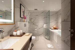 a bathroom with a shower and a tub and a toilet at Sarovar Portico Hanumangarh in Hanumāngarh +22 photos