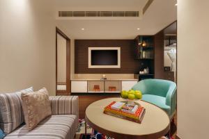 a living room with a couch and a table at Sarovar Portico Hanumangarh in Hanumāngarh