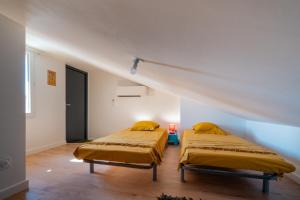 2 letti in una camera bianca con di TIKAZ Béziers - Appartement - 2 Chambres Hyper Centre a Béziers