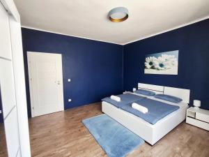 a blue bedroom with a bed and a blue wall at SZEDERMÁLNA Vendégház in Sárospatak