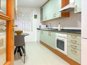 a kitchen with white appliances and a table in it at Los Amantes de Teruel viven aquí in Teruel