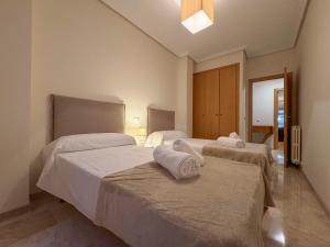 two beds in a hotel room with towels on them at Los Amantes de Teruel viven aquí in Teruel