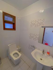a white bathroom with a toilet and a sink at bespoke stays in Mombasa