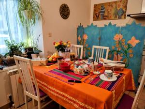 a dining room table with a orange table cloth at Chez Merlyn in Locarn