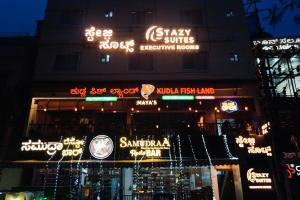 a building with neon signs on the side of it at Stazy Suites Kammanahalli in Bengaluru