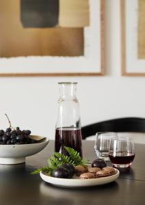 Un plato de aceitunas y una copa de vino en una mesa en MATT - Apartments ' Design-Apartment mit Balkon, en Offenburg