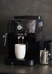 una cafetera con una taza en una encimera en MATT - Apartments ' Design-Apartment mit Balkon, en Offenburg 29 fotos más