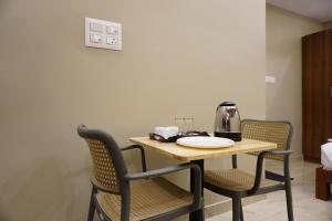 a table with two chairs and a coffee maker on it at Stazy Suites Kammanahalli in Bengaluru
