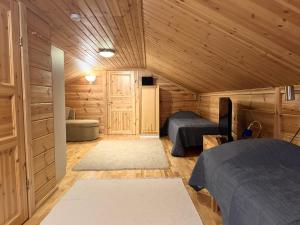 una camera con due letti in una baita di legno di Levi Isorakka Holiday Cabin Pistotie a Kittilä