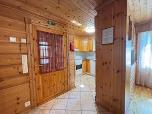 una cucina con pareti in legno e porta in legno di Levi Isorakka Holiday Cabin Pistotie a Kittilä