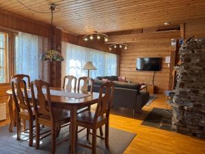 un soggiorno con tavolo, sedie e divano di Levi Isorakka Holiday Cabin Pistotie a Kittilä