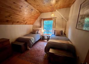 a bedroom with two beds in a room with a wooden ceiling at Perfect Vermont Battenkill Log Cabin in Arlington