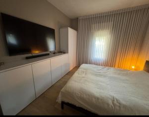 ein Schlafzimmer mit einem Bett und einem Flachbildfernseher in der Unterkunft Cottage near the beach in Kesar Shenaryahu