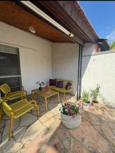 eine Terrasse mit Stühlen, einem Tisch und einem Sofa in der Unterkunft Cottage near the beach in Kesar Shenaryahu
