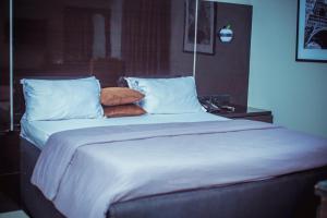 a large bed with white sheets and pillows at Xanders Villa in Mama