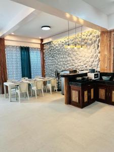 ein Esszimmer mit Tischen und Stühlen und einer Steinmauer in der Unterkunft TEZA by the Z - Beachfront Vacation Villa Rental in Ocoy + 44 Fotos