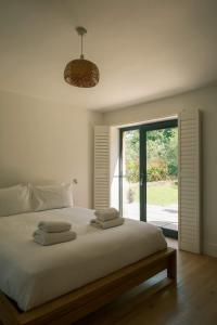 Un dormitorio con una gran cama blanca con ventana. en The Frogs - Cookswood, en Holcombe