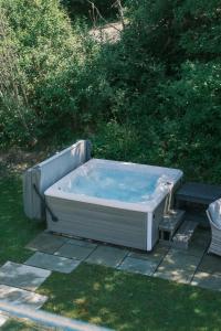 Un jacuzzi sentado en un patio en el césped. en The Frogs - Cookswood, en Holcombe