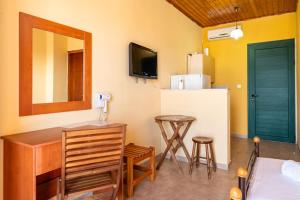 Una cocina con un escritorio, un refrigerador y un taburete. en Gavriil Apartments, en Corfu