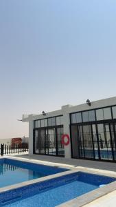 a large building with a swimming pool in front of it at olive tree farm and chalet - مزرعه و شاليه شجره الزيتون  +4 photos