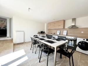 a kitchen with a table and chairs in a kitchen at Le cocon familial - 8min du Futuroscope in Avanton