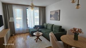 a living room with a green couch and a table at Zlatni TRG in Zlatibor
