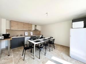 a kitchen with a table and chairs and a refrigerator at Le cocon familial - 8min du Futuroscope in Avanton +4 photos
