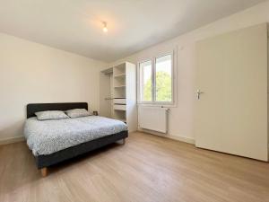 a bedroom with a bed and a window at Le cocon familial - 8min du Futuroscope in Avanton