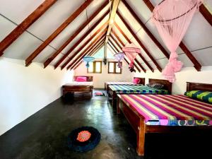 a room with three beds in a attic at Sigiri Birds Hostel in Sigiriya