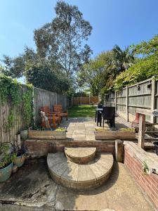 a patio with benches and a table and a fence at “The Reach” Lovely 2 bed house in Gorleston on Sea in Gorleston-on-Sea