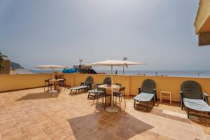 a patio with chairs and tables and umbrellas at Loft Pension Candelaria in Valle Gran Rey