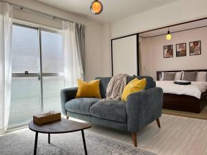 una sala de estar con un sofá y una cama en 456 Mbps 50tv1 4, en Osaka