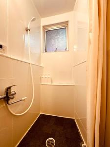 Un baño con ducha y ventana. en 456 Mbps 50tv1 4, en Osaka