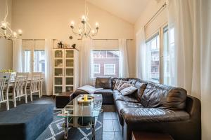 a living room with a leather couch and a table at Alte Levi Dali by Aavalevi Holidays in Levi