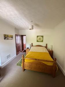 a bedroom with a bed with a yellow comforter at “The Reach” Lovely 2 bed house in Gorleston on Sea in Gorleston-on-Sea