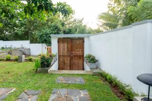 a fence with a wooden door in a yard at Villa Sathkara in Tangalle