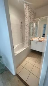 a bathroom with a shower and a tub and a sink at L' Harmonie in Périgueux
