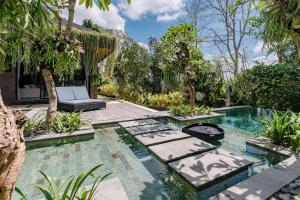 a pool in a backyard with a chair and trees at Merica Luxury Villa Ubud in Gianyar +33 photos