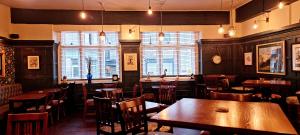 un ristorante con tavoli e sedie e una grande finestra di The Royal Oak, Settle a Settle